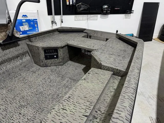 Slide: The Image of 2025 War Eagle MODEL 750 - GLADIATOR boat interior with camouflage pattern in a garage setting. - 6