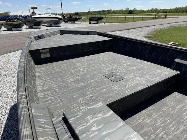 Slide: The Image of 2025 War Eagle 754 LDV boat with camouflage interior, parked outdoors on gravel. - 8