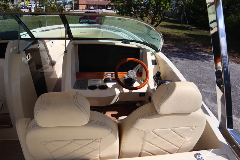 Slide: The Image of 2020 Chris-Craft Calypso 30 helm with beige seats and wooden steering wheel. - 19