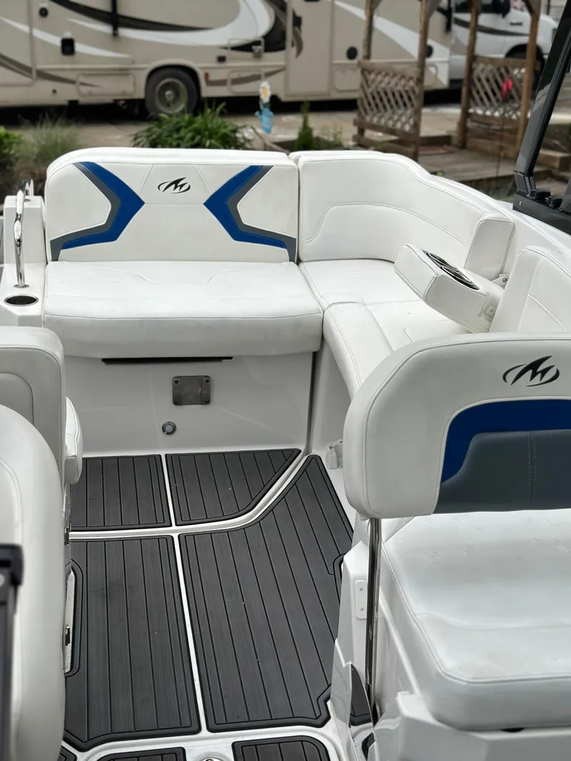 Slide: The Image of 2017 Monterey M6 boat interior with white and blue seating, sleek design, and modern flooring. - 22