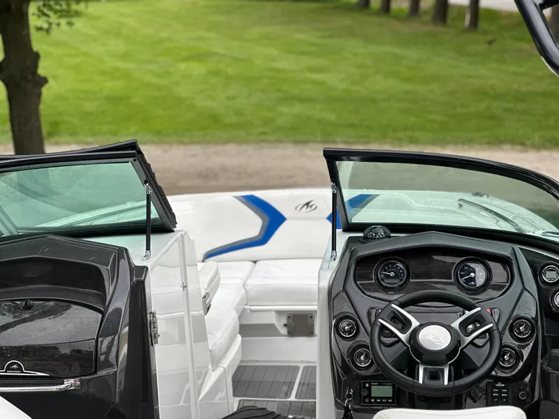 Slide: The Image of 2017 Monterey M6 boat interior with steering wheel and seating, set against a grassy background. - 30