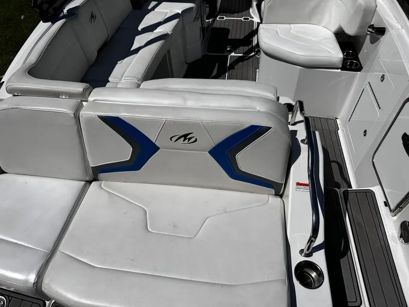 Slide: The Image of 2017 Monterey M6 boat interior with white and blue seating, cup holders, and sleek design. - 38