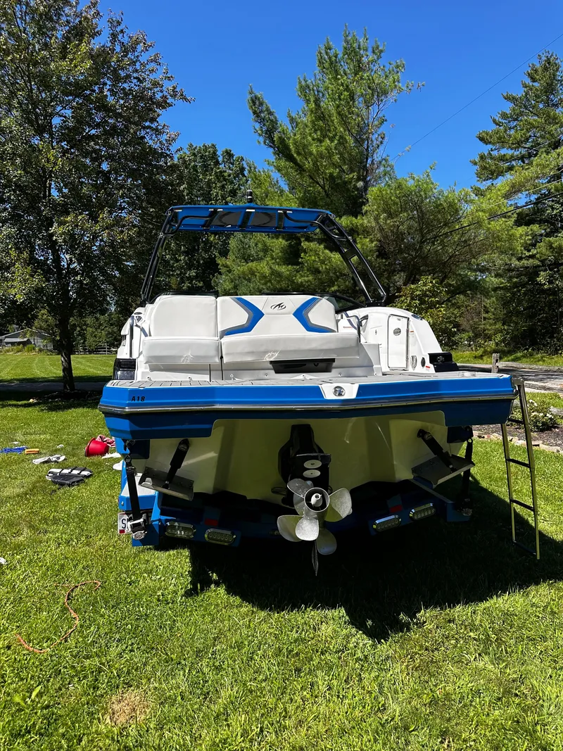 Slide: The Image of 2017 Monterey M6 boat on grass, surrounded by trees under a clear blue sky. - 42