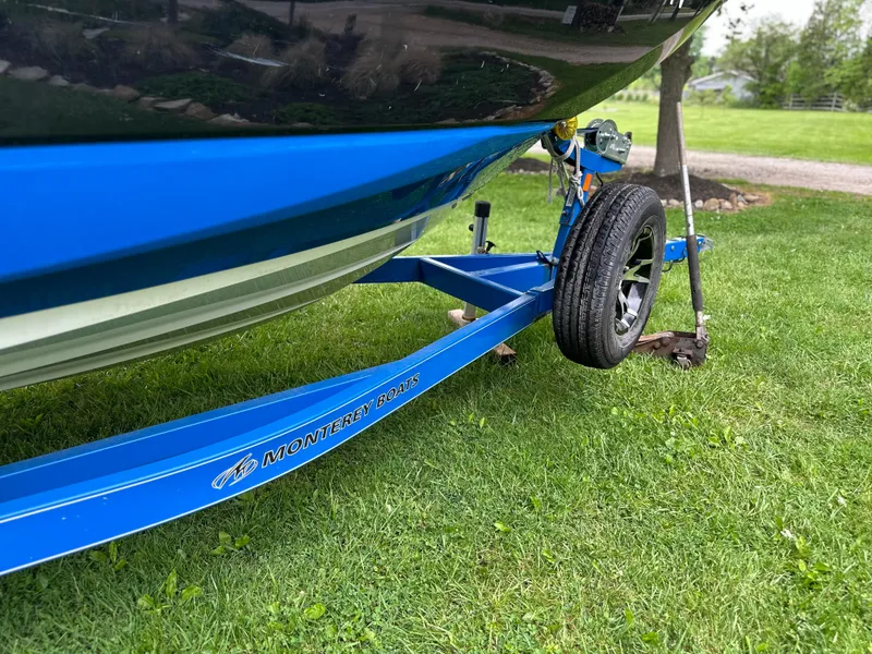 Slide: The Image of 2017 Monterey M6 boat on blue trailer, parked on grass. - 9