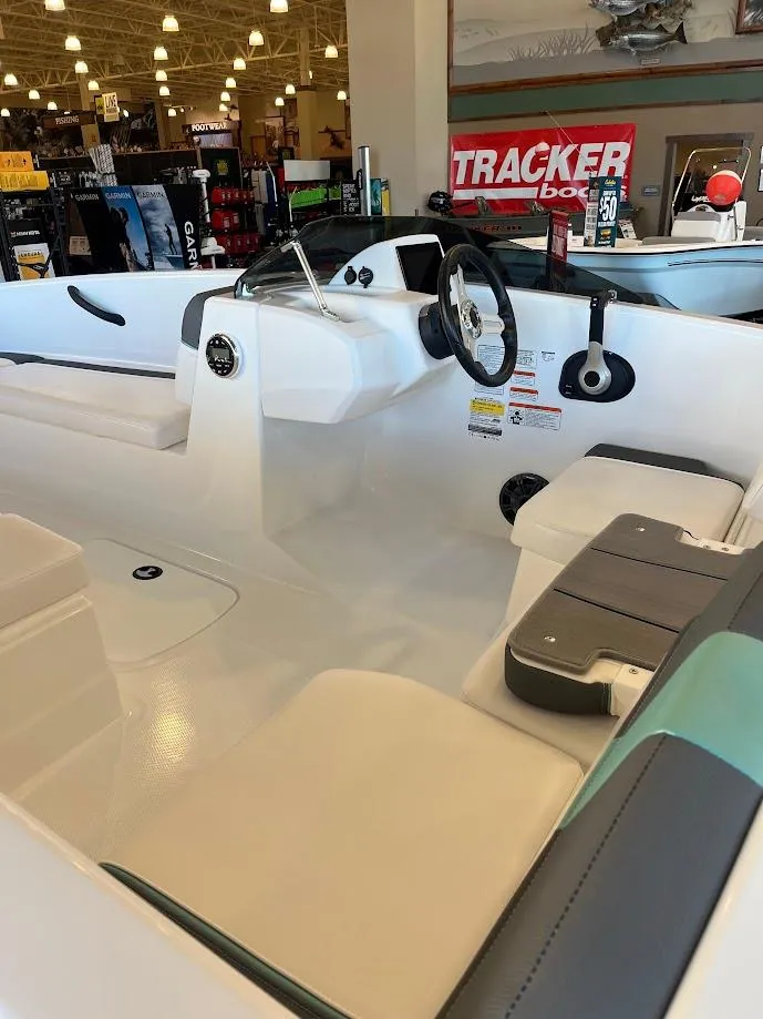 Slide: The Image of 2025 Tahoe T16 boat interior with steering wheel and seating in showroom. - 2