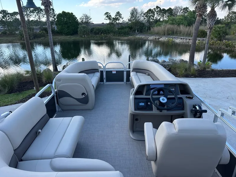 Slide: The Image of 2025 Sun Tracker Party Barge 18 DLX pontoon boat interior by a scenic lake. - 4