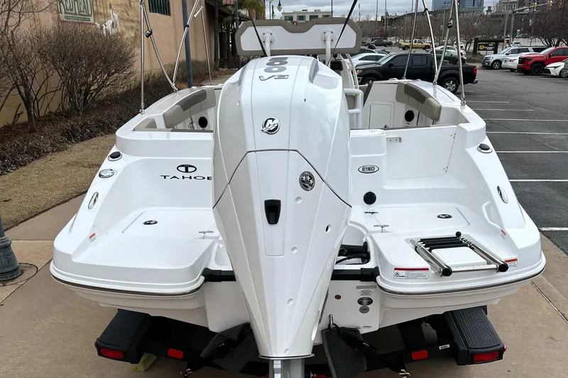 Slide: The Image of 2025 Tahoe 2150 CC boat, rear view, parked on a trailer in a lot. - 4
