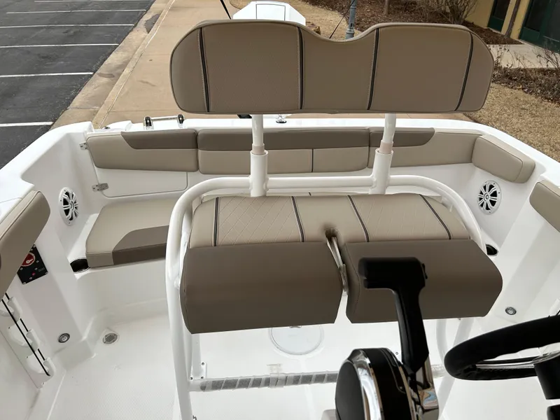 Slide: The Image of 2025 Tahoe 2150 CC boat interior with beige seating and steering console. - 7