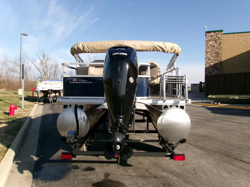 Slide: The Image of 2025 Sun Tracker Bass Buggy 18 DLX pontoon boat parked outdoors. - 3
