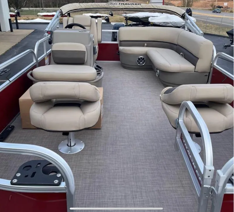 Slide: The Image of 2025 Sun Tracker Bass Buggy 18 DLX pontoon boat interior with beige seating and spacious layout. - 3