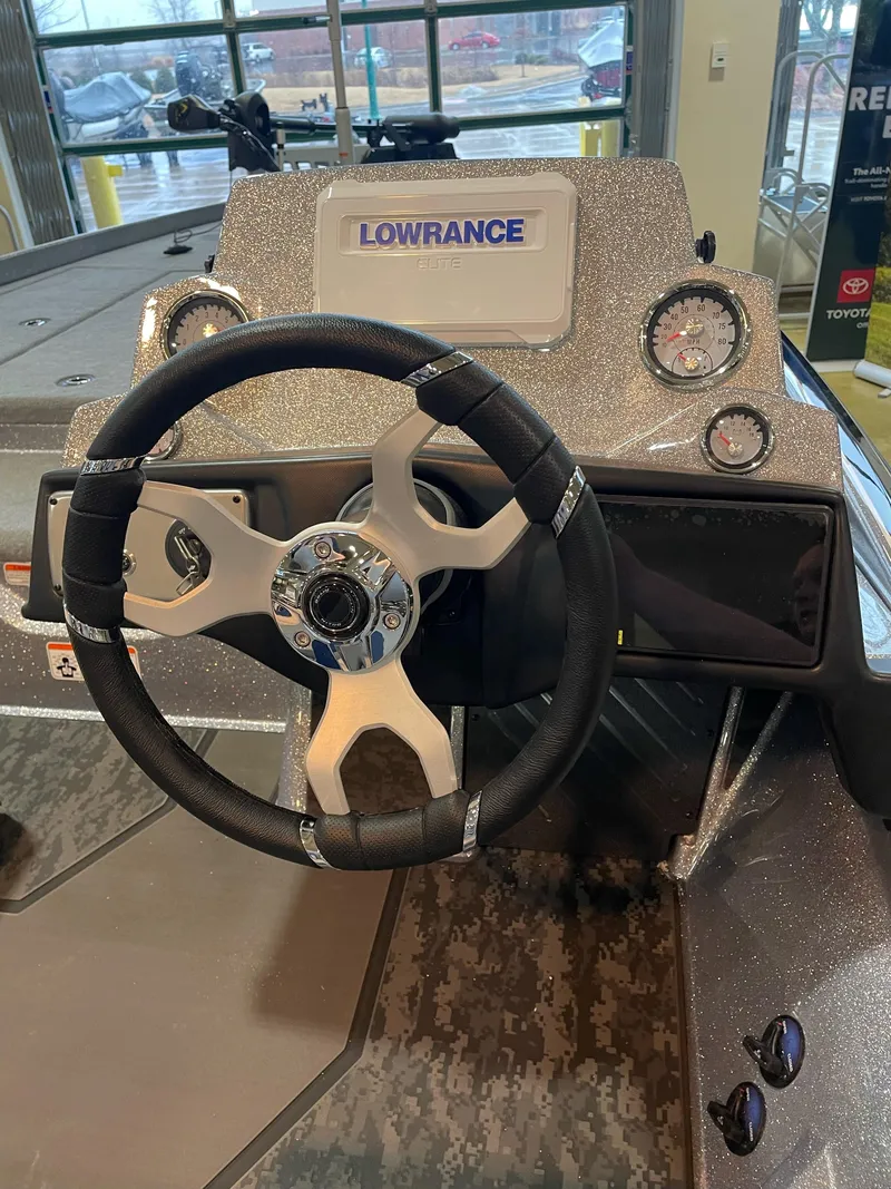 Slide: The Image of 2025 Nitro Z21 XL boat dashboard with Lowrance display and steering wheel. - 2
