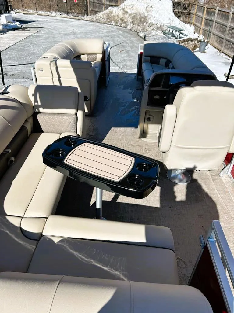 Slide: The Image of 2025 Sun Tracker Party Barge 20 DLX interior with beige seating and table. - 5