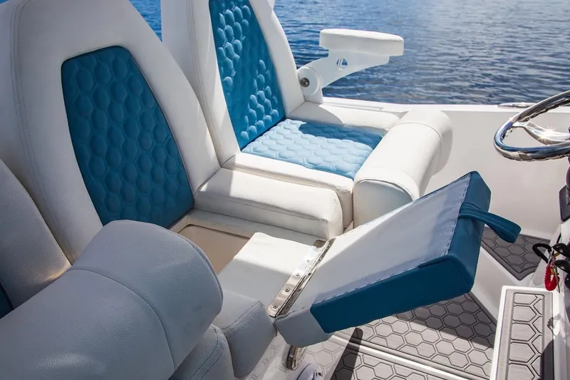 Slide: The Image of 2021 Belzona 32 Walkaround boat interior with blue and white seating, near water. - 6