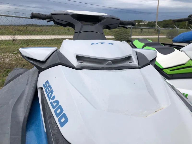 Slide: The Image of 2019 Sea-Doo GTX 155 jet ski, white and blue, parked outdoors. - 2