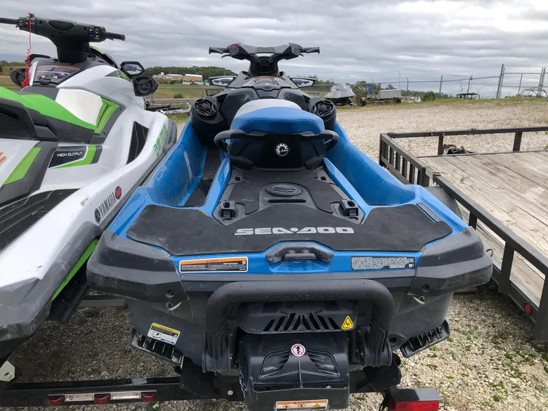 Slide: The Image of 2019 Sea-Doo GTX 155 jet ski in blue, parked on a trailer outdoors. - 3