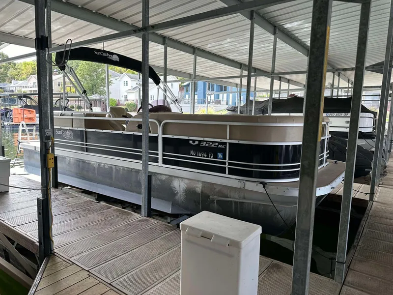 Slide: The Image of 2013 G3 SunCatcher V322 RC pontoon boat docked under a covered marina. - 1