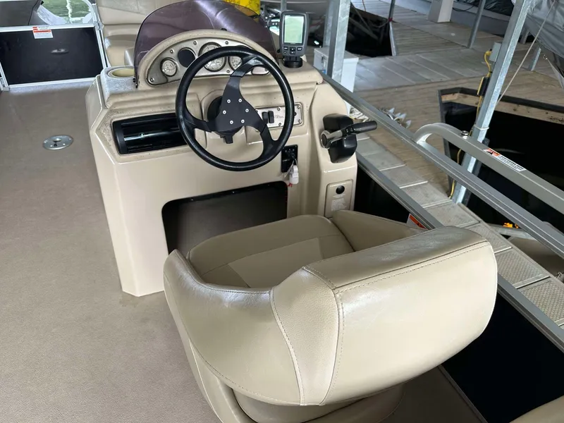 Slide: The Image of 2013 G3 SunCatcher V322 RC boat interior with steering wheel and beige seating. - 11