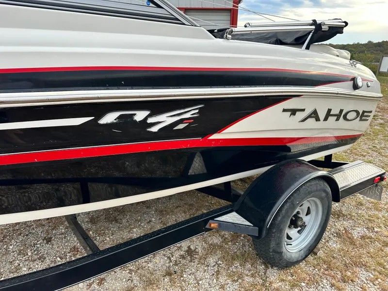 Slide: The Image of 2013 Tahoe Q4i boat on trailer, featuring sleek black and red design. - 12