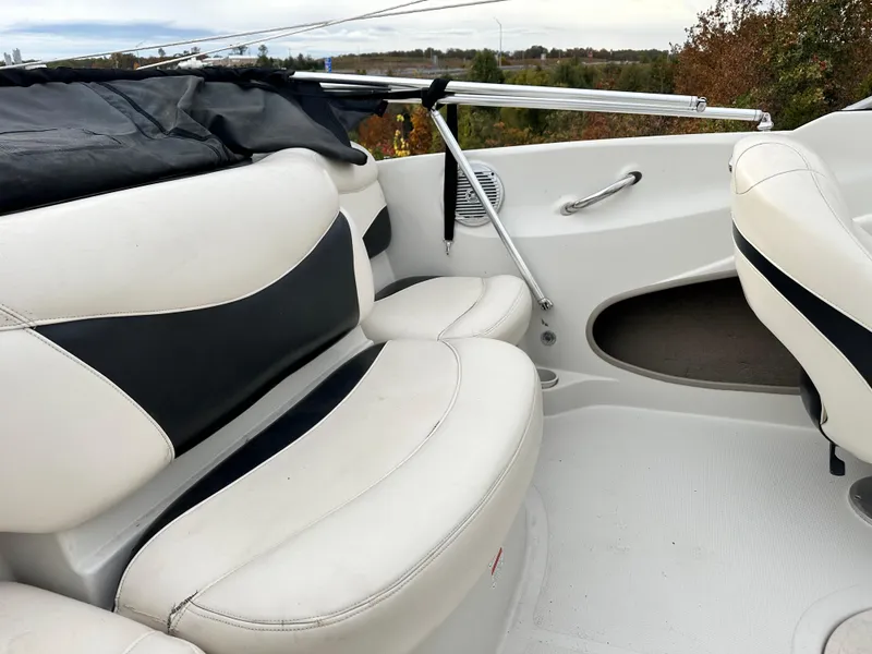 Slide: The Image of 2013 Tahoe Q4i boat interior with white and black seating, outdoor setting. - 9
