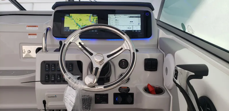 Slide: The Image of 2025 Regal 26 XO boat on calm water under a cloudy sky. - 1