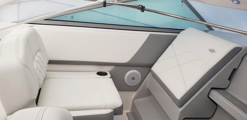 Slide: The Image of 2025 Regal 26 XO boat deck with railing, parked near vehicles and a fence. - 2