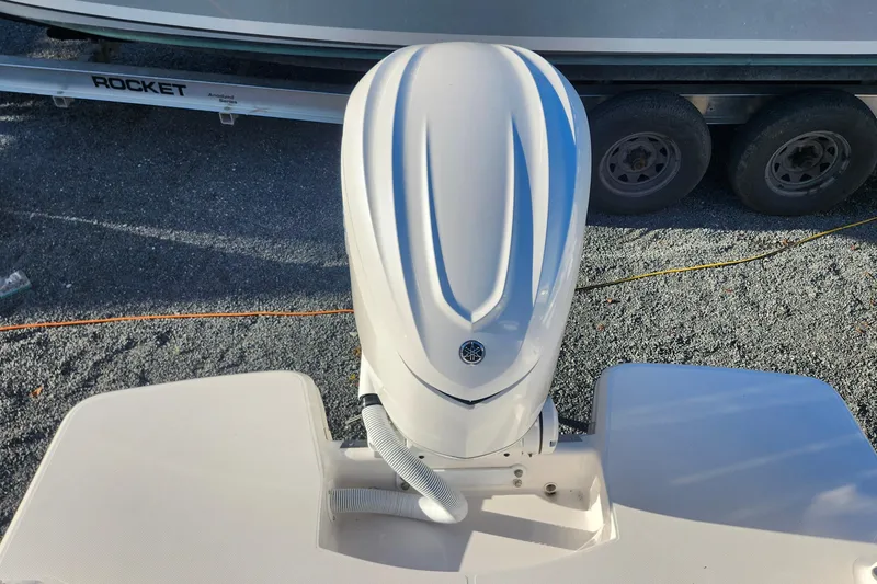 Slide: The Image of 2025 Regal 26 XO boat with Yamaha outboard engine, parked on gravel near trailer. - 24