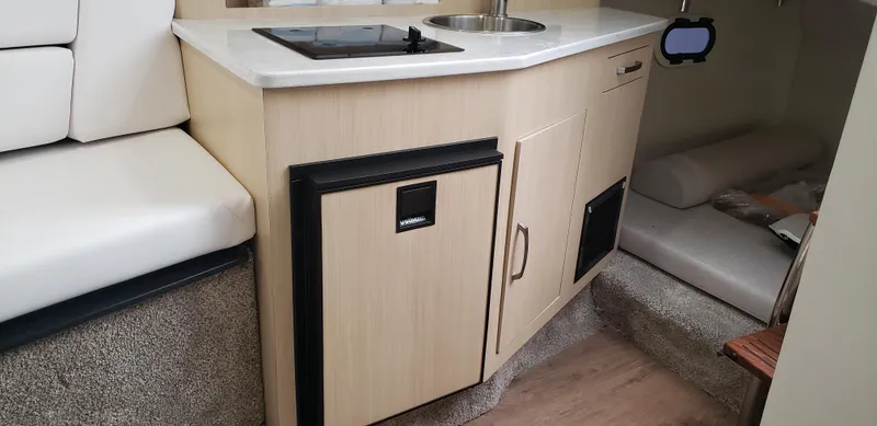 Slide: The Image of 2025 Regal 26 XO boat interior with kitchenette and seating area. - 28