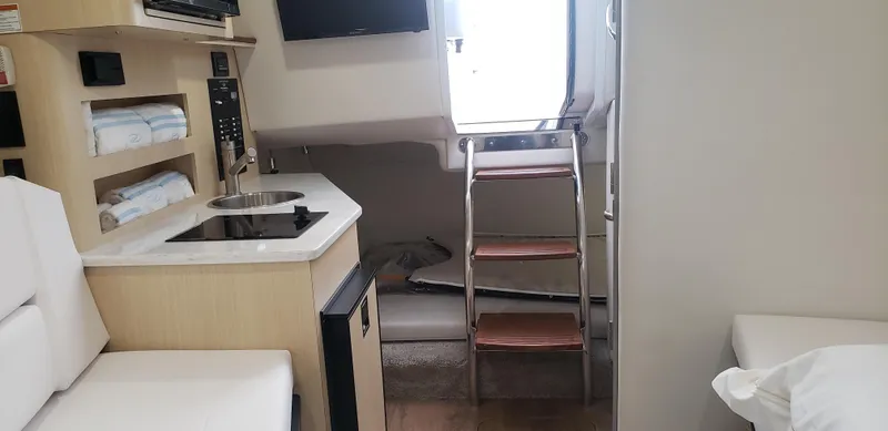 Slide: The Image of Interior of 2025 Regal 26 XO boat with kitchenette and ladder. - 35