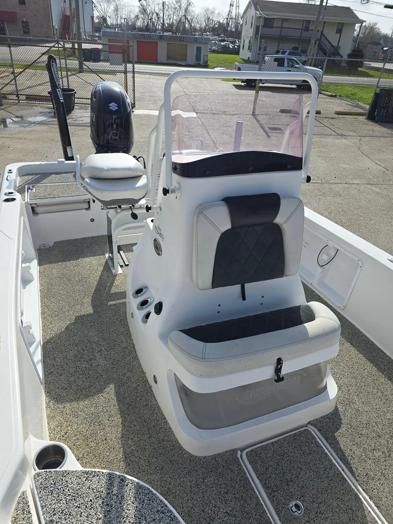 Slide: The Image of 2019 Blue Wave 2200 PureBay boat with seating and console, parked outdoors. - 12