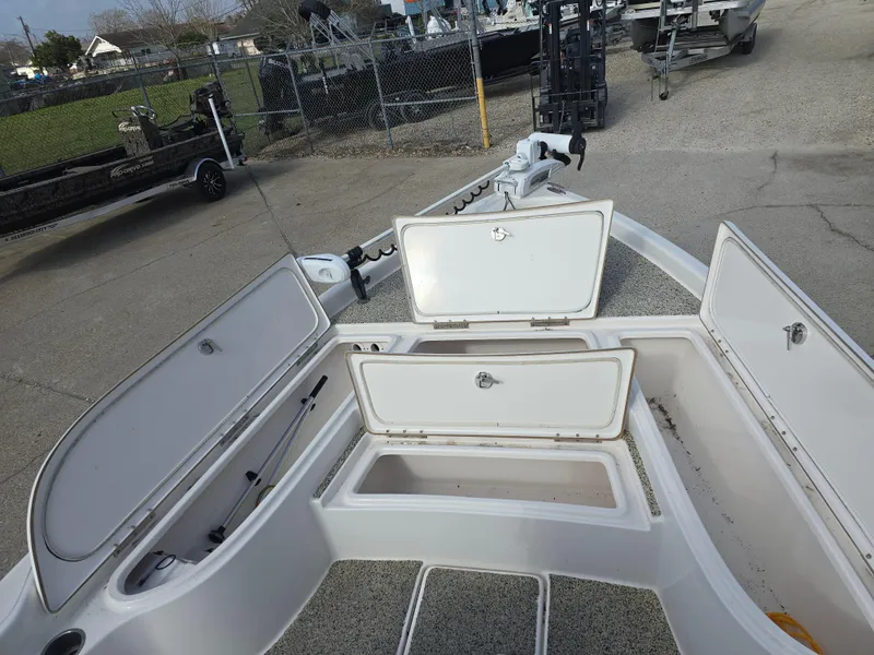 Slide: The Image of 2019 Blue Wave 2200 PureBay boat with open storage compartments, docked outdoors. - 13