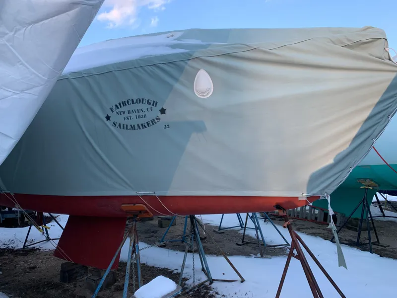 Slide: The Image of 2003 Alerion Express 28 sailboat covered, on stands, with snow around. - 11