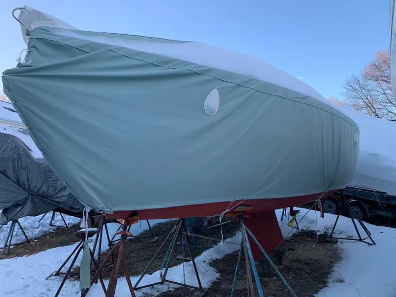 Slide: The Image of Alerion Express 28 sailboat, 2003 model, covered and elevated on stands in a snowy yard. - 13