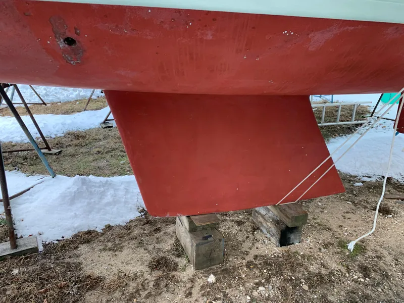 Slide: The Image of Alerion Express 28 sailboat keel, 2003 model, on dry land with snow in background. - 14