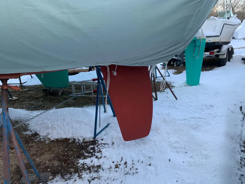 Slide: The Image of 2003 Alerion Express 28 sailboat keel in snowy outdoor storage. - 16