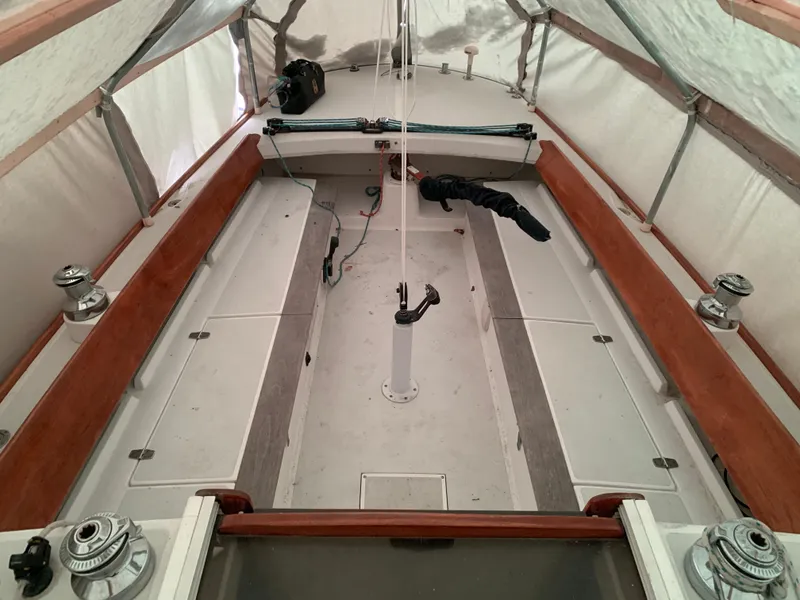 Slide: The Image of 2003 Alerion Express 28 sailboat interior under cover, showcasing spacious cockpit and seating. - 21