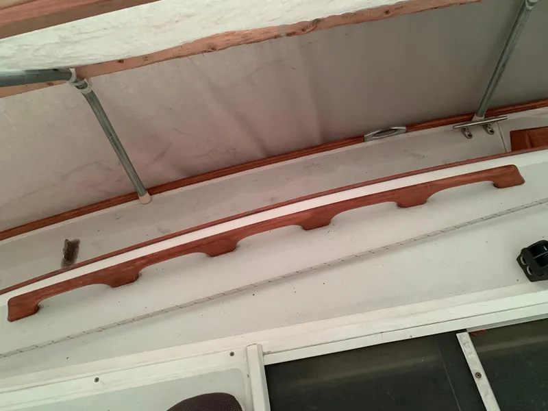 Slide: The Image of Wooden handrail on Alerion Express 28 sailboat, 2003 model, under a canopy. - 22