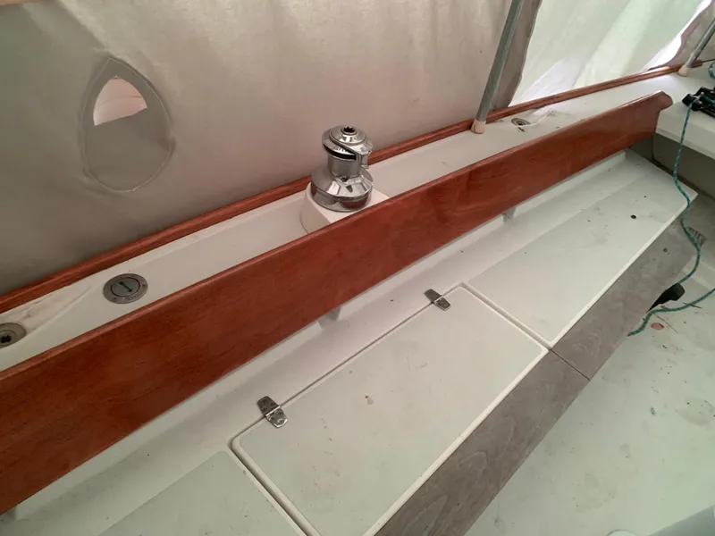 Slide: The Image of Alerion Express 28 sailboat deck with winch, 2003 model, featuring wooden trim. - 24