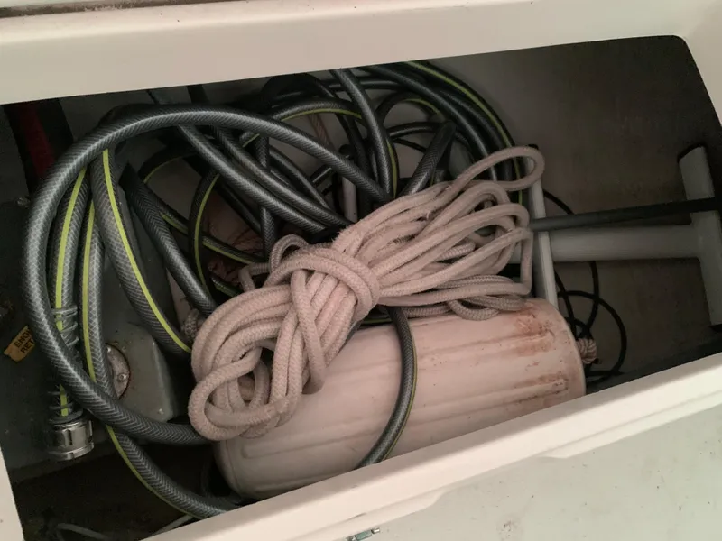 Slide: The Image of Storage compartment of a 2003 Alerion Express 28 with ropes and hoses. - 25