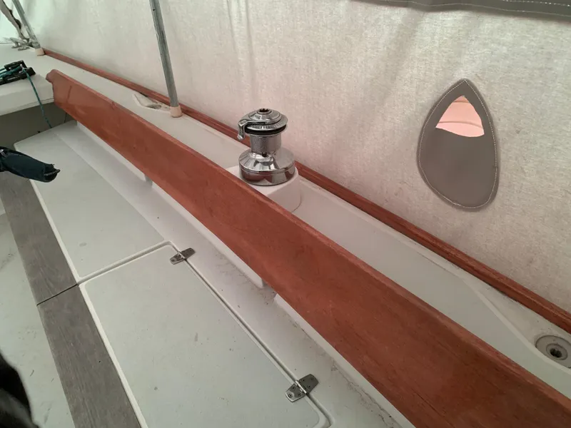 Slide: The Image of Interior view of a 2003 Alerion Express 28 sailboat, featuring a winch and wooden trim. - 27