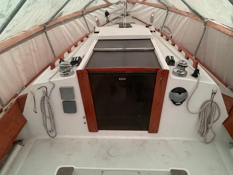 Slide: The Image of 2003 Alerion Express 28 sailboat under cover, showcasing deck and cockpit area. - 30