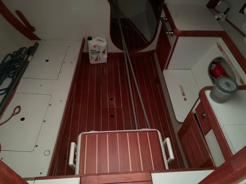 Slide: The Image of Interior of a 2003 Alerion Express 28 sailboat with wooden flooring and storage compartments. - 36