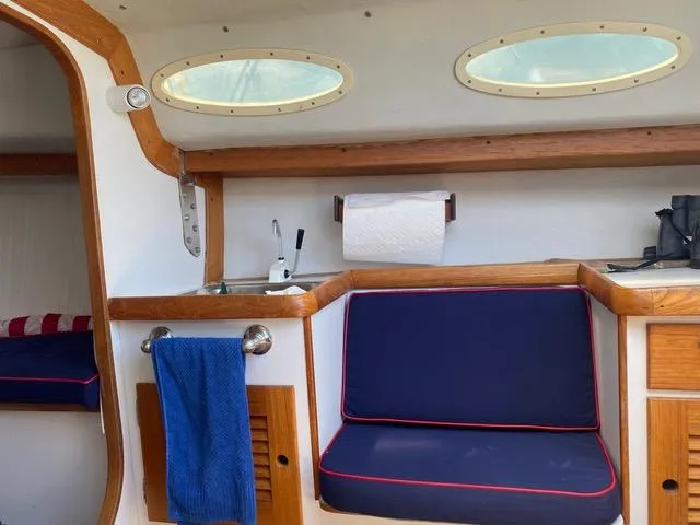 Slide: The Image of Interior of 2003 Alerion Express 28 sailboat with blue seating and wooden accents. - 39