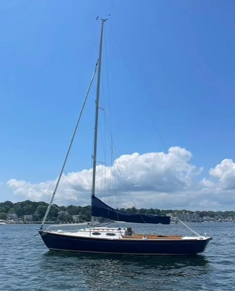 Slide: The Image of 2003 Alerion Express 28 sailboat on calm water under a clear blue sky. - 4