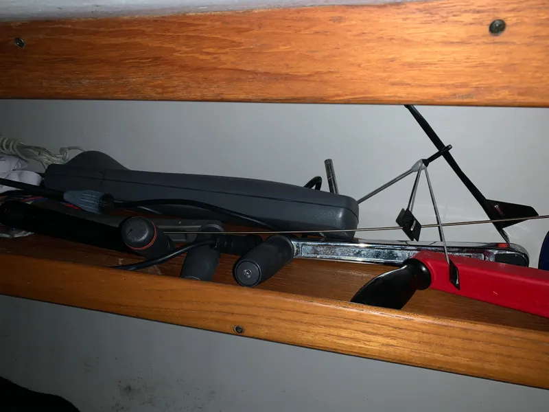 Slide: The Image of Sailing equipment stored on a wooden shelf inside a 2003 Alerion Express 28 boat. - 48