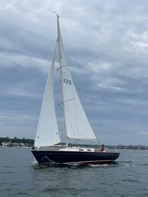 Slide: The Image of Alerion Express 28 sailboat from 2003 on calm waters under a cloudy sky. - 7