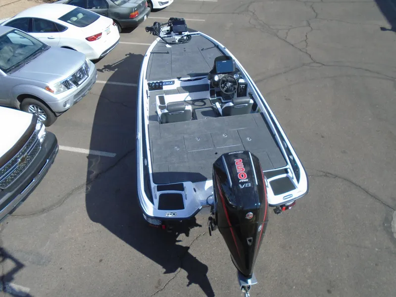 Slide: The Image of 2025 Phoenix 721 ZXL bass boat with outboard motor in a parking lot. - 7