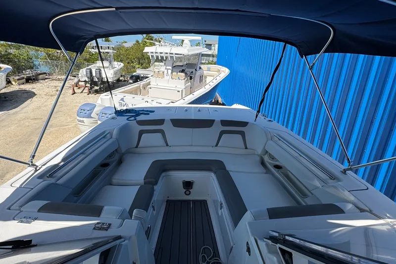 Slide: The Image of 2020 World Cat 28 DCX boat with spacious seating and canopy, docked near blue building. - 9
