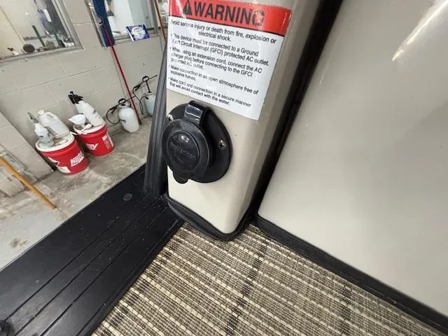 Slide: The Image of 2019 Harris Grand Mariner 250 power outlet with warning label in a workshop setting. - 23
