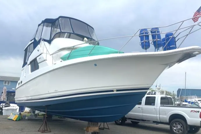 The Image of 1996 Silverton 372 Motor Yacht on dry dock, with blue and white exterior. - 0