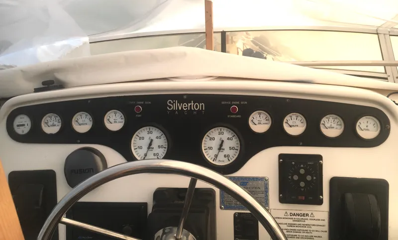 Slide: The Image of 1996 Silverton 372 Motor Yacht dashboard with gauges and steering wheel. - 19